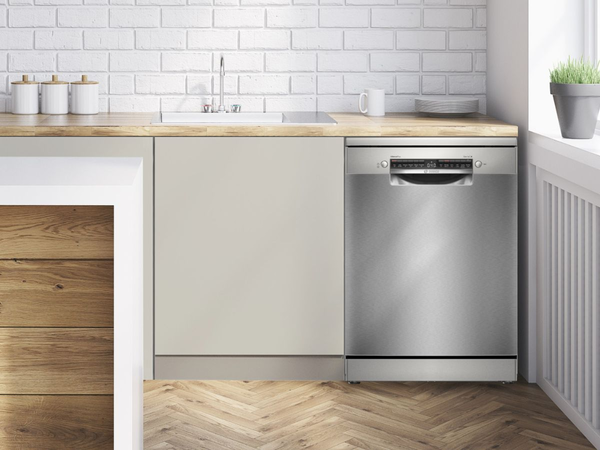 Một máy rửa chén âm nhỏ có cửa mở và đầy đủ kệ