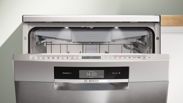 Một máy rửa chén âm nhỏ có cửa mở và đầy đủ kệ