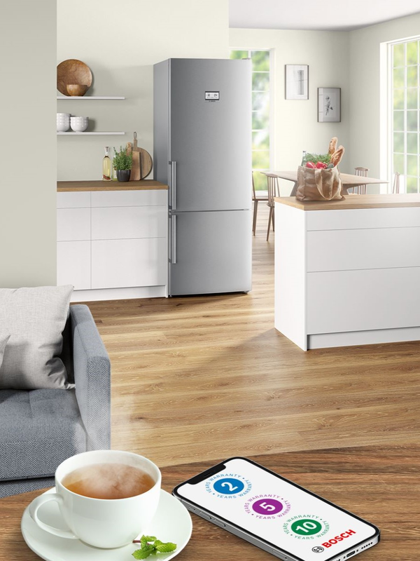 Light open kitchen and living area with mobile showing Bosch 2, 5 and 10 year warranty icons