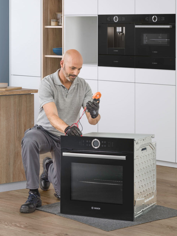 Engineer checking Bosch oven appliance in kitchen