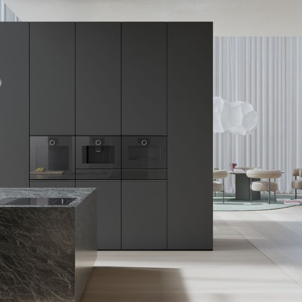 View into an open plan luxury kitchen fitted with Gaggenau Minimalistic series appliances.