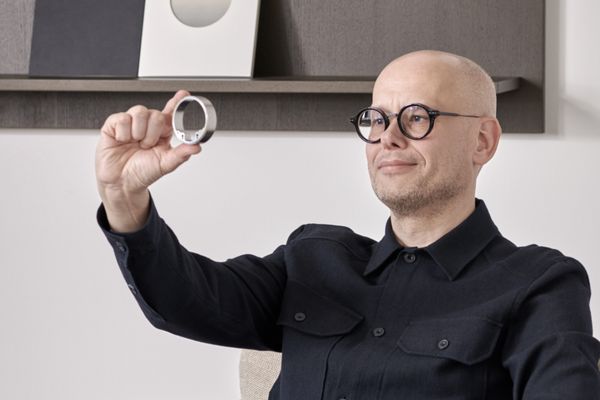 Portrait of Soeren Strayle, User Interaction and Interface Designer holding up the stainless-steel ring to the light