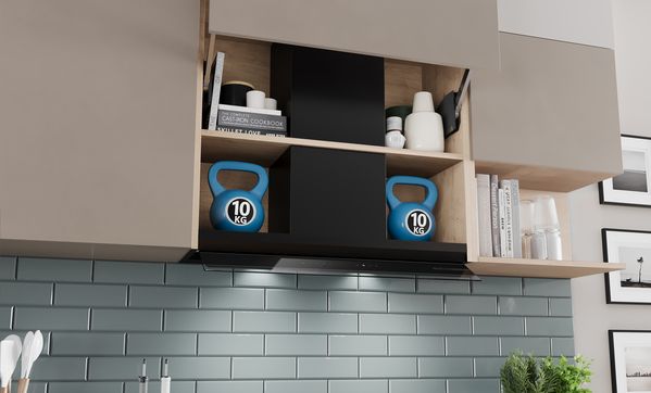 Аспиратор за пълно вграждане с отворен и запълнен стенен шкаф. От лявата и дясната страна на уреда е поставена пудовка с тегло 10 кг, за да се илюстрира товароносимостта.