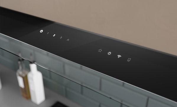 Изглед отгоре на потребителския интерфейс върху разгънат стъклен панел на аспиратор за пълно вграждане.