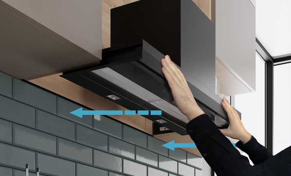 Плъзнете аспиратора за пълно вграждане с две ръце по водещите релси в стенния шкаф.