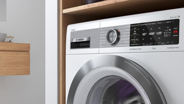 A close-up view of the control panel and upper part of a white Bosch front-load washing machine