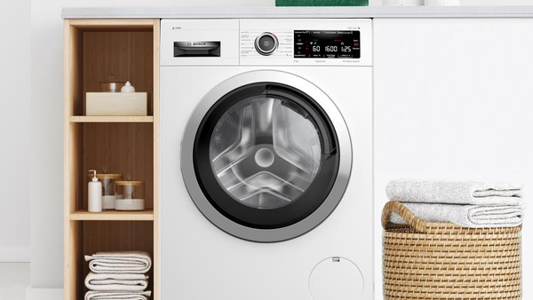 A close-up of a front-loading washing machine with its door open, revealing the drum