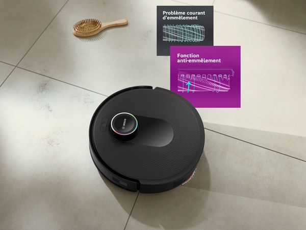 Le Spotless sur un sol carrel&eacute; blanc propre avec une brosse &agrave; cheveux, mettant en avant la fonction de r&eacute;duction des enchev&ecirc;trements.