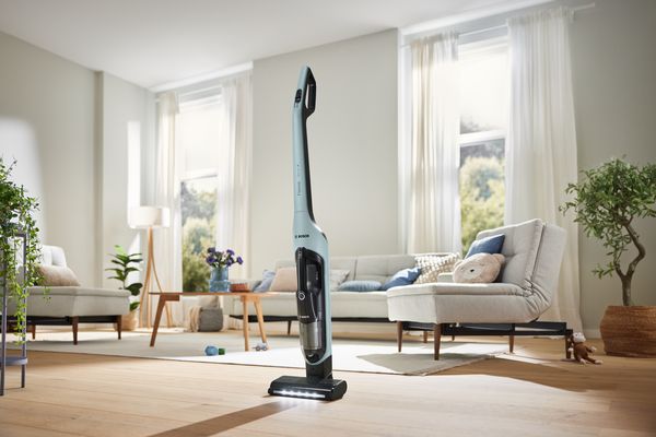 Безкабелната прахосмукачка Flexxo стои в средата на всекидневна.