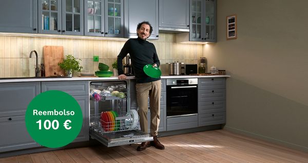Hombre en cocina con lavavajillas, el reembolso ofrece hasta 150 euros.