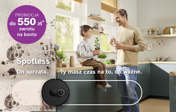 Robot sprzatajacy na dywanie, obok mezczyzna i chlopczyk przy stole