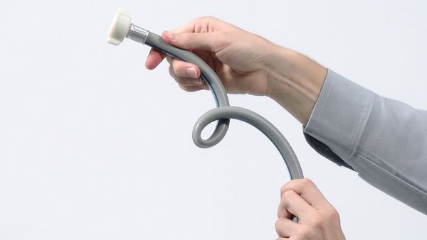 Mani che tengono il tubo di carico o di scarico dell’acqua.