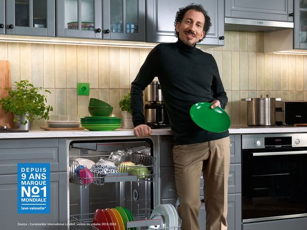 Homme tenant une assiette verte dans ses mains.