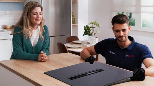 Cocina moderna con tableta que muestra controles caseros inteligentes, electrodomésticos y encimera de madera.
