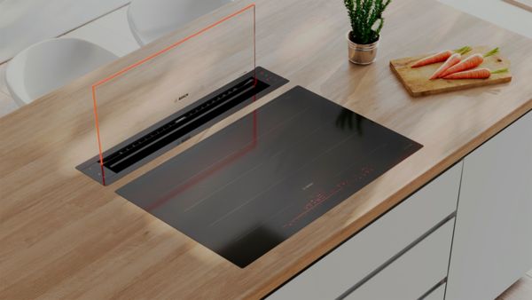 Готварски плот с вграден абсорбатор на дървен плот, с растение и моркови наблизо.