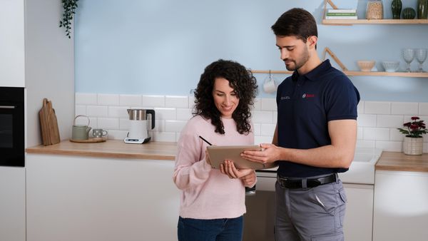 Hombre del servicio técnico viendo y explicando a una usuaria