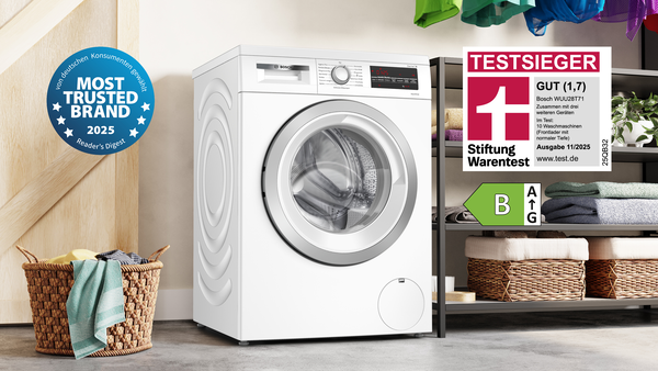 Waschmaschine umgeben von Handtüchern und Ablagen.