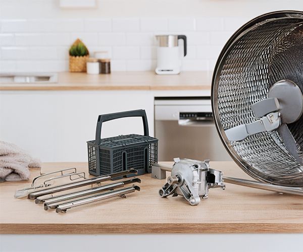 Kitchen countertop with an air fryer, cooking tools, a basket, and small appliances, creating a modern cooking setup.