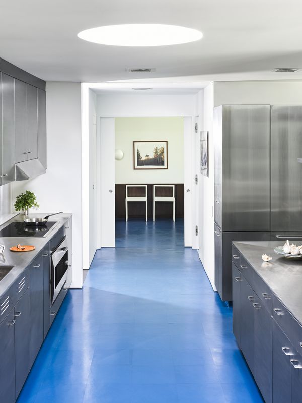 Kitchen view showing the distinctive blue coloured floor continuing through to the next room