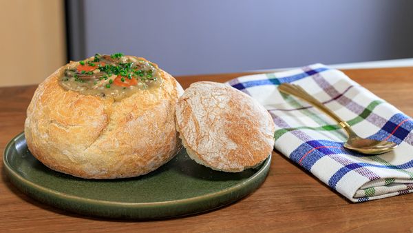 Soup in a bread bowl displayed neatly on a plate
