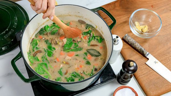 stirring remaining ingredients together in a pot to make soup