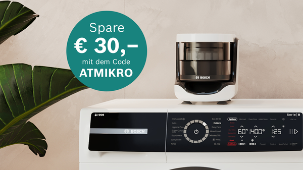 Weiße Bosch-Waschmaschine mit digitalem Display und Drehregler, daneben grüner Kreis mit Text 'Spare € 30,- mit dem Code ATMKRO'.