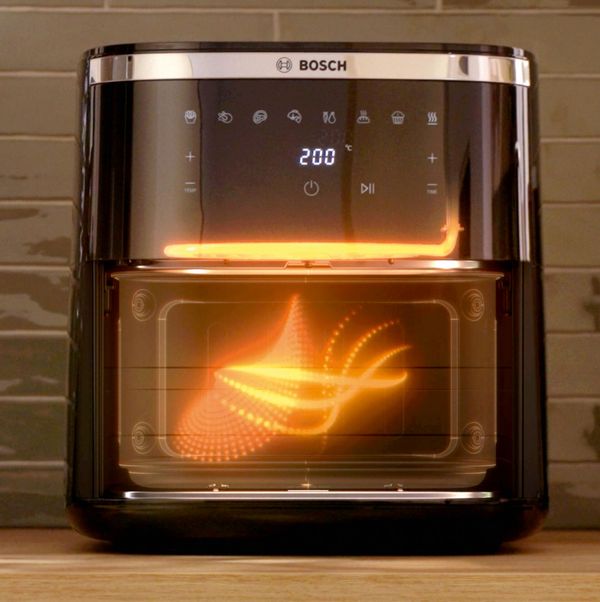 Friggitrice ad aria Bosch in funzione, con luce interna arancione che mostra il flusso di calore all&rsquo;interno del cestello