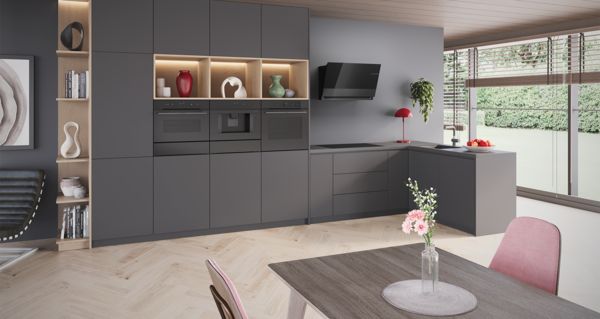 Елегантен, черен индукционен плот Bosch с готвещо се ястие от сьомга и зеленчуци.