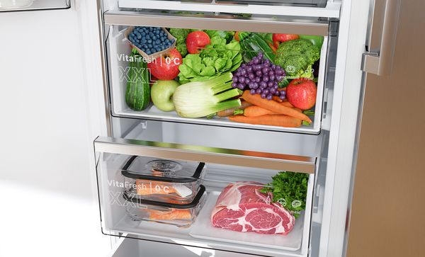 Чекмедже VitaFresh 0&deg;C XXL пълно с прилежно организирани пресни продукти, докато в чекмеджето отдолу се съхраняват охладена сьомга, месо и билки.