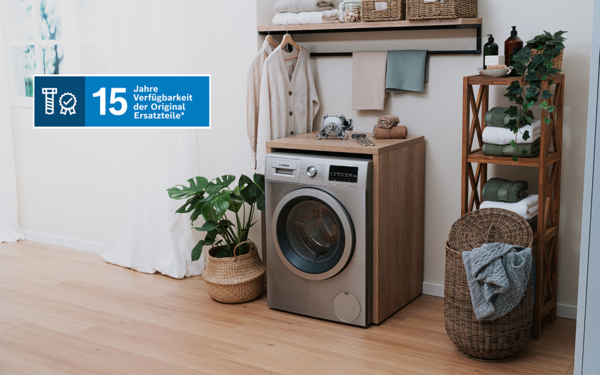 Silberner Waschmaschine im Raum mit Handtüchern und Wäsche