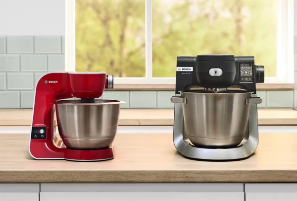 2 מיקסרים של בוש מונחים על השיש מעץ. השמאלי בצבע אדום הימני בצבע שחור