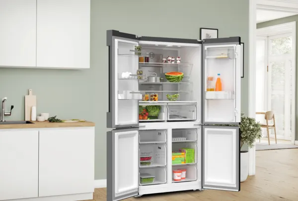 מקרר 4 דלתות של בוש עם דלתות פתוחות לצד ארונות מטבח לבנים עם שיש עץ