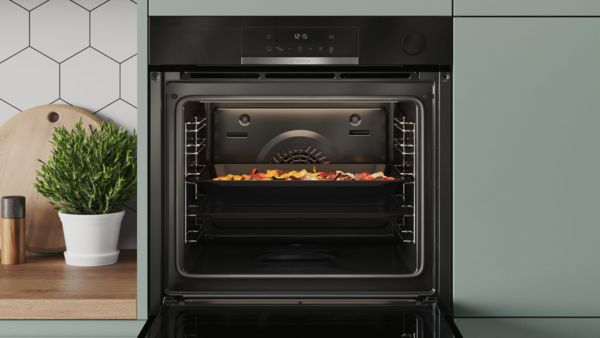 Open Bosch built-in oven with Air Fry function, Air Fry tray with crispy food visible in the cooking chamber.