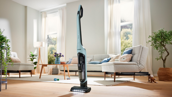 The cordless vacuum Flexxo stands in the middle of a  living room.