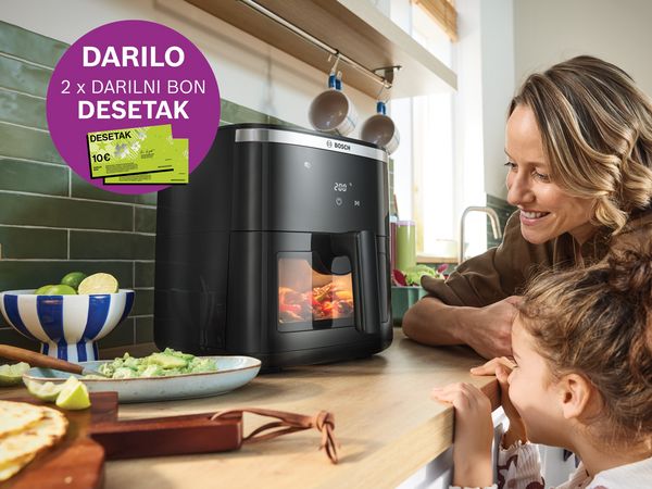 Robotski sesalnik čisti dnevno sobo z družino, znak "10 let jamstva".