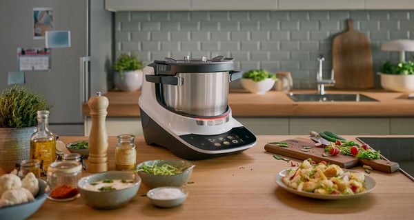 Bosch Cookit K&uuml;chenmaschine mit Kochfunktion auf einer Arbeitsfl&auml;che mit Zutaten.