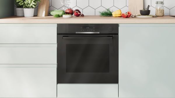 Вградена фурна на Bosch с контроли за плота в дървена кухня. 