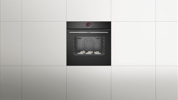 Фурна Bosch, вградена в бели шкафове, с тава с целувки, които се пекат вътре.