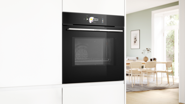 Ağ dolablara quraşdırılmış Bosch sobası; ekranda "Baking Sensor" g&ouml;stərilir. M&uuml;asir mətbəx fonu.