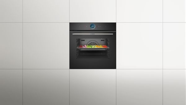 Модерна кухненска фурна с цифров дисплей, заобиколена от минималистичен интериор на хола.