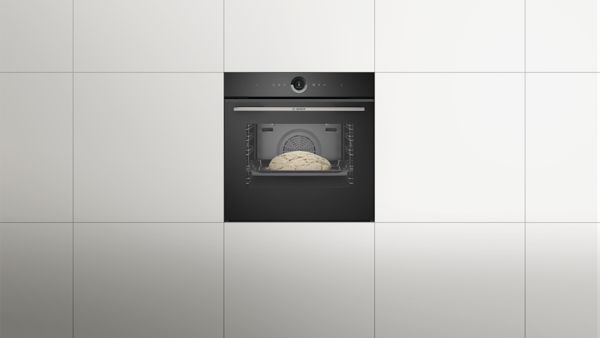 Фурна Bosch с втасващ вътре хляб; екран, показващ настройките за готвене.