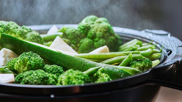 Gem&uuml;se wie Brokkoli und Zucchini im Dampfgaraufsatz des Bosch Cookit beim schonenden Dampfgaren.