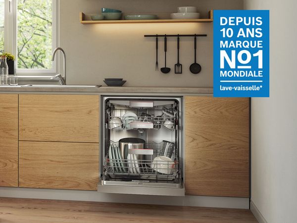 Cuisine moderne avec armoires blanches, &icirc;le en bois, lave-vaisselle, et un panneau bleu faisant la publicit&eacute; d'une marque.