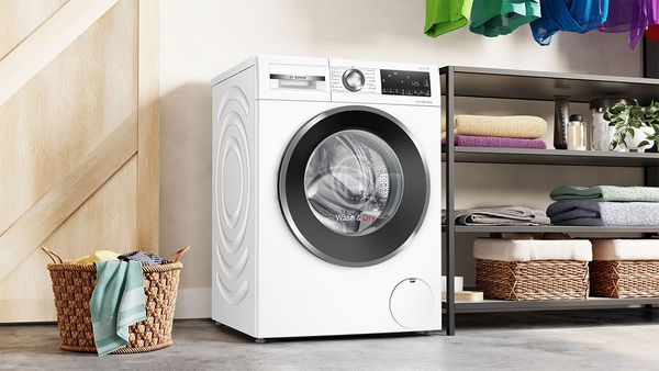 A washing machine and dryer next to each other in a modern bathroom.
