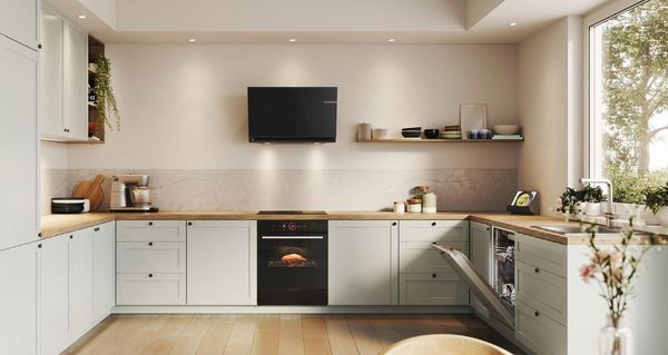 Bilden visar ett gr&aring;tt k&ouml;k i lantlig stil som k&ouml;ksinspiration, med svarta vitvaror fr&aring;n Bosch.