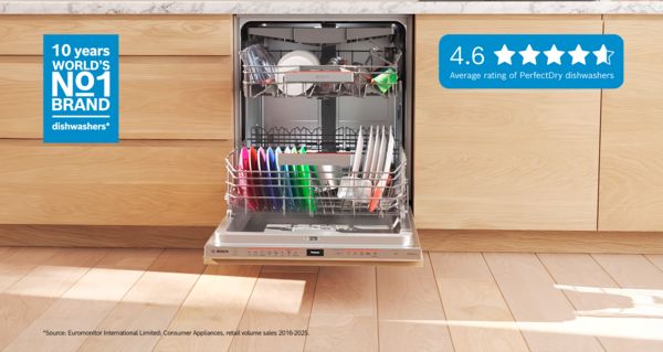 Lavastoviglie Bosch aperta con piatti colorati al suo interno, inserita in una cucina moderna con mobili in legno.
