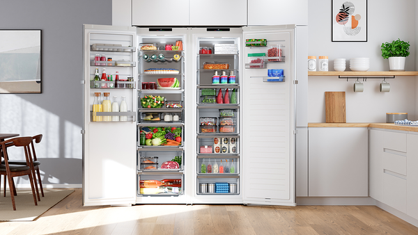 Zwei freistehende, eint&uuml;rige K&uuml;hl- bzw. Gefrierger&auml;te von Bosch in einer hellen K&uuml;che mit Holzboden.