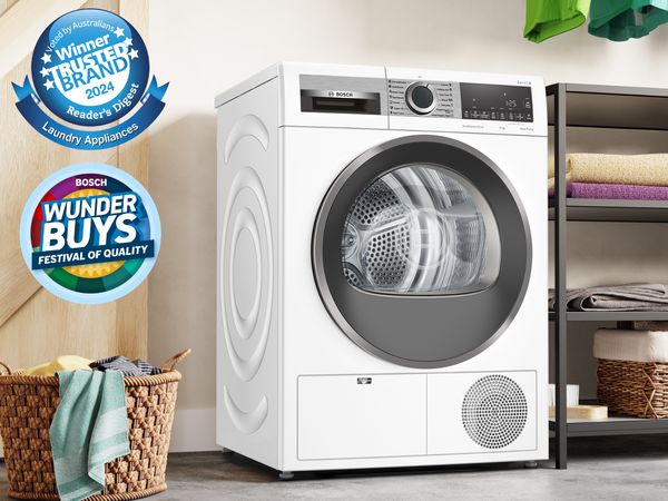 Bosch front-load dryer in an organised laundry with folded towels and Reader&rsquo;s Digest Trusted Brand badge. 