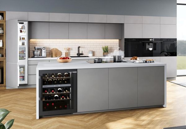 Bilden visar ett modernt gr&aring;tt k&ouml;k med k&ouml;ks&ouml;. K&ouml;ket har integrerade vitvaror fr&aring;n Bosch.