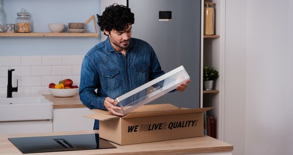 Un client Bosch dans sa cuisine avec un kit de pi&egrave;ces de rechange.